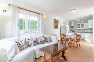 a living room with a white couch and a table at Spacious family home with Airco, private 5x10m pool, sandy beach 300m, free WiFi in Denia