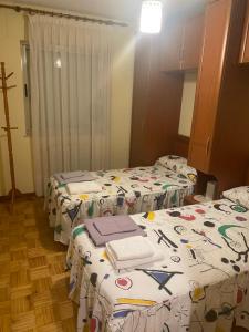 a room with three beds in a room at Apartamento Couto in Ribadeo