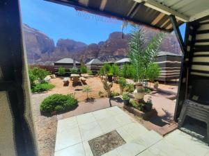 uitzicht op een patio met bergen op de achtergrond bij Bedouin Village Hostel in Wadi Rum