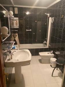 a bathroom with a sink and a toilet and a shower at Apartamento Couto in Ribadeo +7 photos