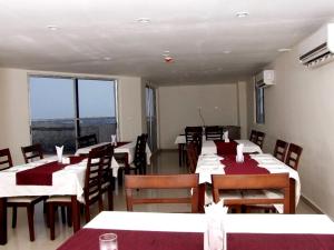 uma sala de jantar com mesas e cadeiras com toalhas de mesa vermelhas em The Townhall (Unit of Prohotel) em Chennai