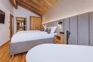 a large bedroom with two beds and a television at ZAGLGUT Premium Hotel & Chalets, Zell am See-Kaprun - Wellness & Infinity Pool, Air Conditioning, Panoramic Views & Summer Card Included in Kaprun +90 photos