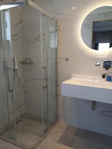 a bathroom with a glass shower and a sink at Flâneur apartments in Ormos Panagias +24 photos