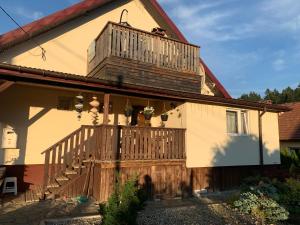a house with a wooden deck and a balcony at APARTMENT DOR-Ali u Ali in Żubracze