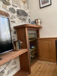 a tv sitting on a wooden shelf next to a stone wall at Charmant appartement, centre piéton Vieille Ville Annecy in Annecy