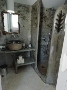 a stone bathroom with a sink and a shower at Studio farma in Zefiría