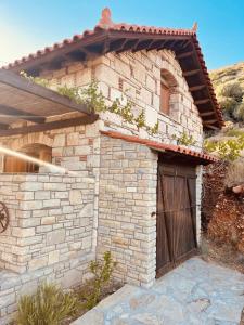 une maison en briques avec une porte en bois sur le côté dans l'établissement Villa Margarita, à Samos