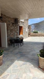 a patio with a table and chairs in a stone building at Kea Petra Studios in Korissia