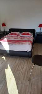 łóżko z czerwoną i białą kołdrą w sypialni w obiekcie CHALET INDIVIDUEL TRES ENSOLEILLE AU CALME VUE IMPRENABLE w mieście Saint-Étienne-de-Tinée