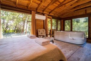 a bedroom with a large tub and a bed with towels at Sea Valley Lodge in Faralya