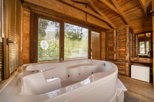 a large white tub in a room with windows at Sea Valley Lodge in Faralya