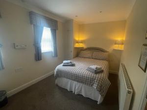 a bedroom with a bed with two towels on it at Vane House in Osmotherley