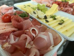 - un plateau de nourriture avec de la viande et du fromage sur une table dans l'établissement Oleander Romantik Zimmer, à Trausdorf