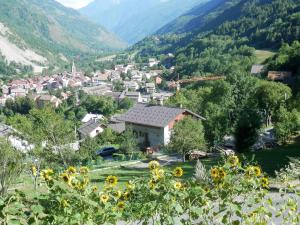 miasteczko w górach z polem słoneczników w obiekcie CHALET INDIVIDUEL TRES ENSOLEILLE AU CALME VUE IMPRENABLE w mieście Saint-Étienne-de-Tinée