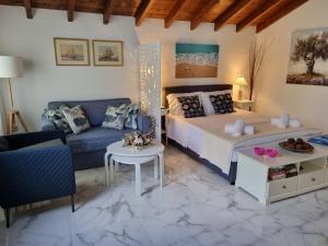 a bedroom with a bed and a couch at VILLA TELLINA in Skiathos