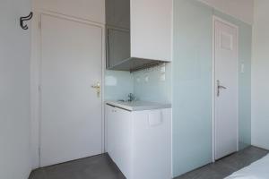 a kitchen with white cabinets and a sink at Apartment With Terrace In Piraeus in Piraeus