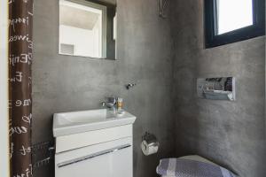 a bathroom with a sink and a toilet and a mirror at Apartment With Terrace In Piraeus in Piraeus