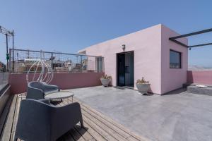 a patio with chairs and a table on a building at Apartment With Terrace In Piraeus in Piraeus