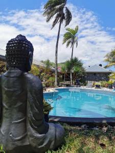 a statue sitting in front of a swimming pool at Les Grands Monts in Saint-Joseph