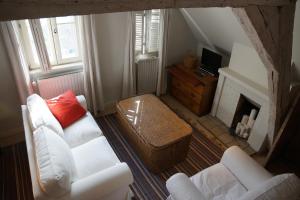 a living room with two white couches and a fireplace at Studio Rempart in Brussels