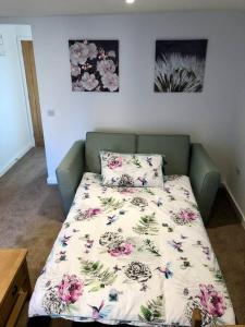 a bed with a floral comforter in a room at No 28D St Benedict in Glastonbury