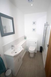 a white bathroom with a sink and a toilet at No 28D St Benedict in Glastonbury
