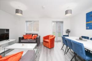 uma sala de estar com um sofá, uma mesa e cadeiras em Modern 5 Bedroom 3 Bathroom Serviced House Aylesbury with parking By 360Stays em Aylesbury