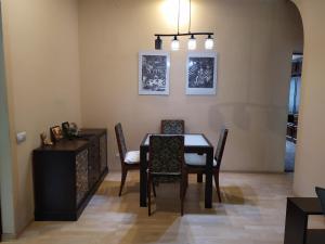 a dining room with a table and chairs and a cabinet at Three Bedroom Stepana Bandery Street in Rivne