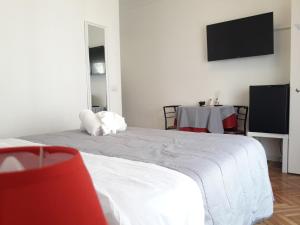 1 dormitorio con 1 cama y TV en la pared en Affittacamere L'Orchidea, en Ventimiglia