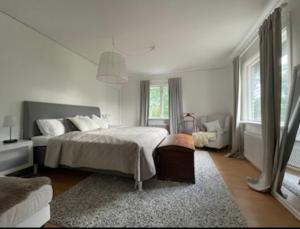 a white bedroom with a bed and a couch at Beautiful Home in the Swedish landscape in Vissefjärda