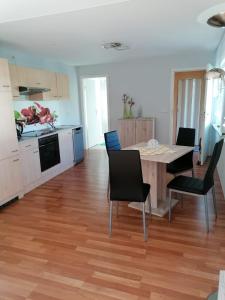 cocina y comedor con mesa y sillas en Ferienwohnung am See, en Heldrungen
