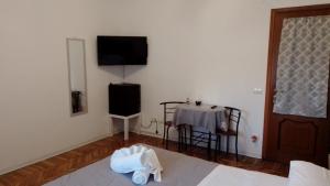 a room with a table and a television and a bed at Affittacamere L'Orchidea in Ventimiglia