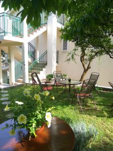 a patio with chairs and a table in the grass at Apartment Villa Radovic II in Risan