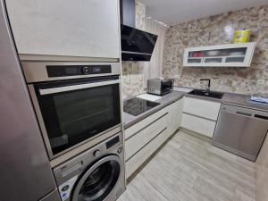 een kleine keuken met een wasmachine en droger. bij DS Ribera, con aparcamiento opcional in Córdoba