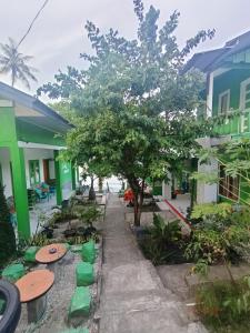 un patio con un árbol y algunos edificios en AAL Homestay, en Sabang