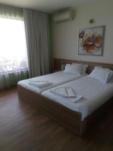 una camera da letto con un grande letto con lenzuola bianche e una finestra di Prado Beach a Sunny Beach