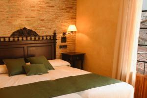 a bedroom with a bed and a brick wall at Hotel Rural Villa de Vinuesa in Vinuesa