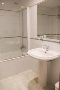 a bathroom with a sink and a mirror and a tub at Hotel Rural Villa de Vinuesa in Vinuesa