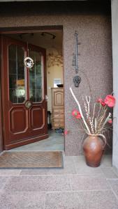a front door of a house with a vase with flowers at Ferienhaus mit Pool zum Träumen und Entspannen für alle Sinne in Bad Schmiedeberg
