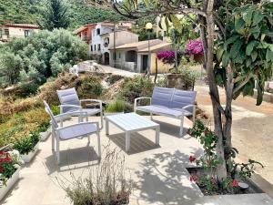 3 sedie blu e un tavolo su un patio di MP Luxury House a Budoni