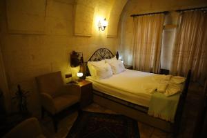 a bedroom with a bed and a chair and a window at Castle Inn Cappadocia in Ürgüp