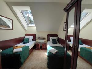 Schlafzimmer im Dachgeschoss mit 2 Betten und einem Spiegel in der Unterkunft Forrest style Pokoje gościnne in Warschau