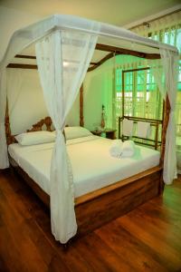 ein Schlafzimmer mit einem Himmelbett in der Unterkunft The Barnsbury House in Nuwara Eliya