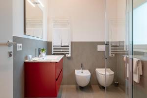a bathroom with a red cabinet and a toilet at Superior Beach Aparthotel in Lido di Jesolo