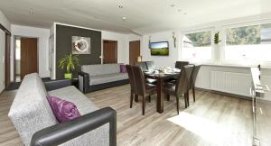 a living room and dining room with a table and chairs at Kühne's 4 Sterne Komfort-Apartments in Braunlage
