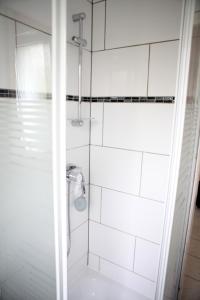 een badkamer met een douche met witte tegels bij White House Castrop Rauxel in Castrop-Rauxel