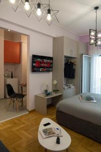 1 dormitorio con cama, escritorio y mesa en Stylish Modern Studio in the Heart of Athens en Atenas