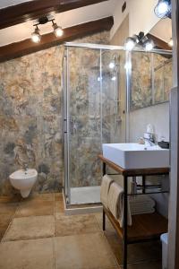 uma casa de banho com um lavatório e um chuveiro em B&B Four Winds em Follina