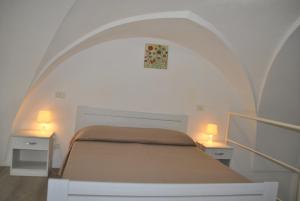 una camera con un letto con due tavoli e due lampade di Monolocali a Palazzo Rizzelli a Santa Cesarea Terme