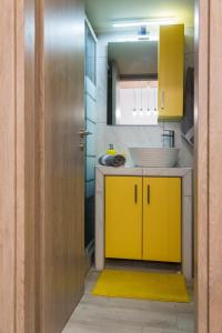 uma casa de banho com armários amarelos e um tapete amarelo em Stylish Modern Studio in the Heart of Athens em Atenas